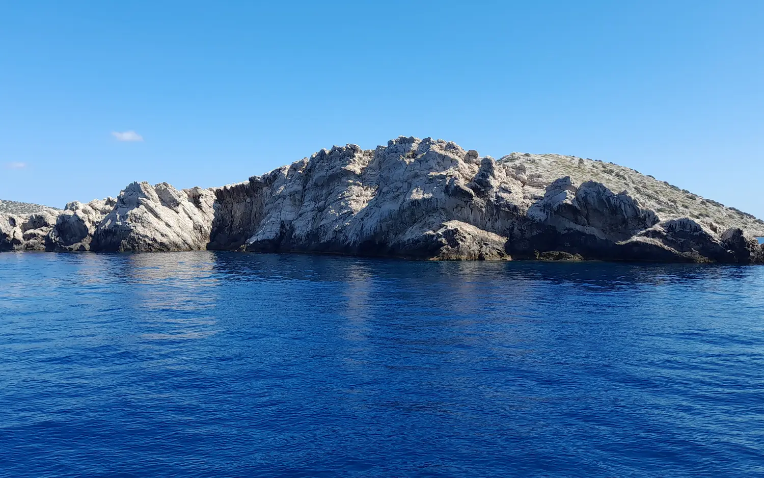 A bare white karst island of the Kornati archipelago rising from the deep blue Adriatic, northern Dalmatia, Croatia