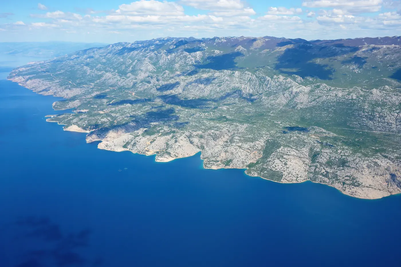Aerial view of the bare Velebit mountain ridge dropping into the deep blue Adriatic, Northern Velebit National Park, Croatia