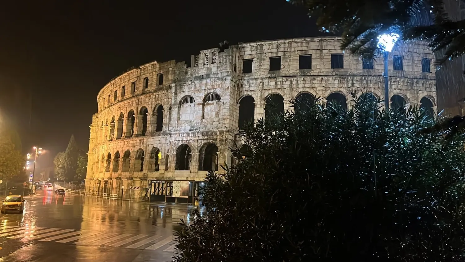 The Roman amphitheatre of Pula lit up at night after rain, Istria, Croatia